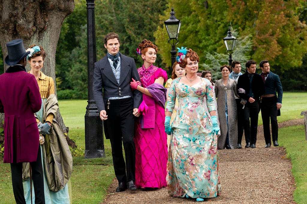 Rupert Young as Lord Jack Featherington, Bessie Carter as Prudence Featherington, Nicola Coughlan as Penelope Featherington, Polly Walker as Lady Portia Featherington, Florence Emilia Hunt as Hyacinth Bridgerton, Ruth Gemmell as Lady Violet Bridgerton, Luke Newton as Colin Bridgerton, Jonathan Bailey as Anthony Bridgerton, Luke Thompson as Benedict Bridgerton in episode 207 of "Bridgerton" (Liam Daniel/Netflix)