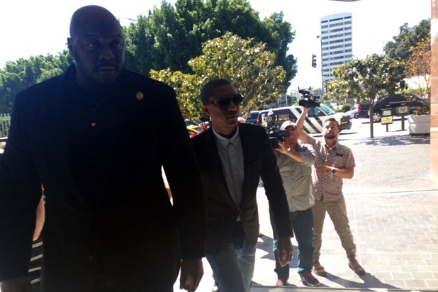 Pharrell Williams arrives at court in Los Angeles with a bodyguard for the "Blurred Lines" trial