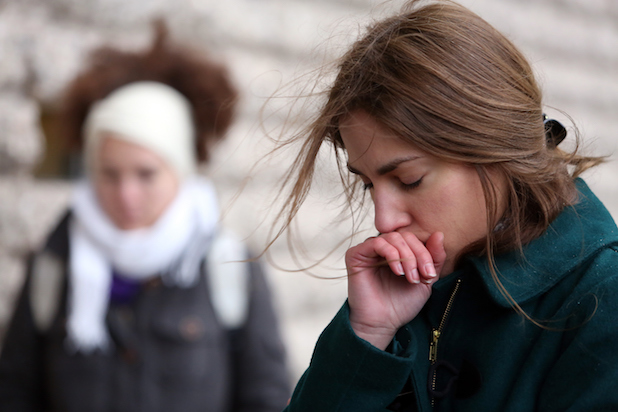 A woman bows her head at a rally to honor journalists killed at Charlie Hebdo