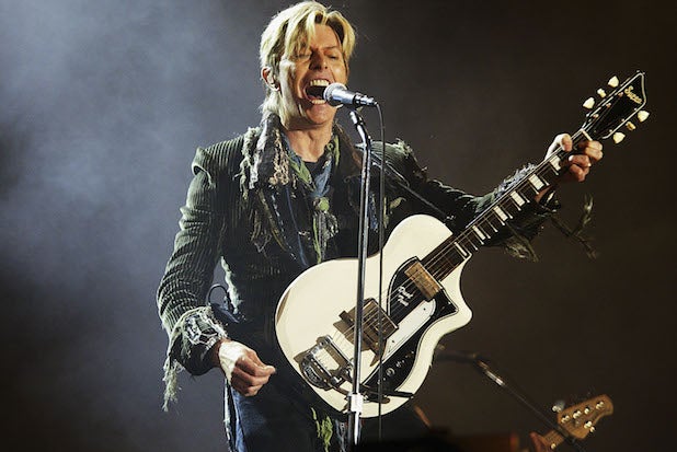 David Bowie performs with a guitar in 2004