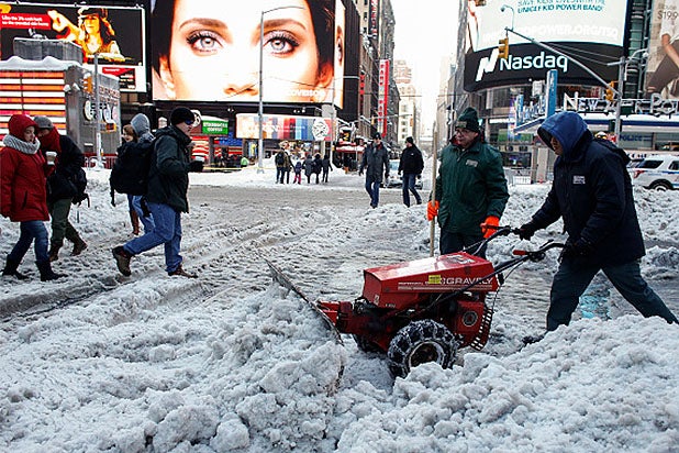 Times Square employees clean a snow covered street in Times Square on January 24, 2016 in New York.
