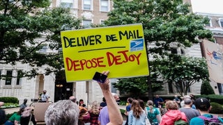 Protesters Stage ‘Wake-Up Call’ in Front of Postmaster General’s House