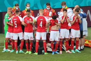 teammates surrounding christian eriksen