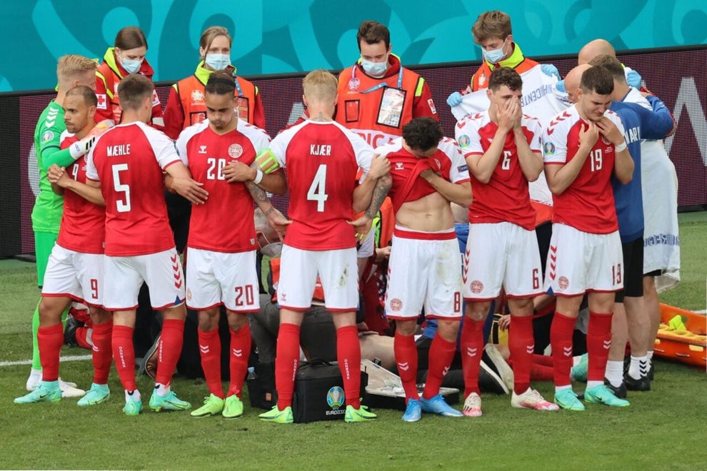 teammates surrounding christian eriksen