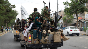 Taliban members ride in a pickup truck