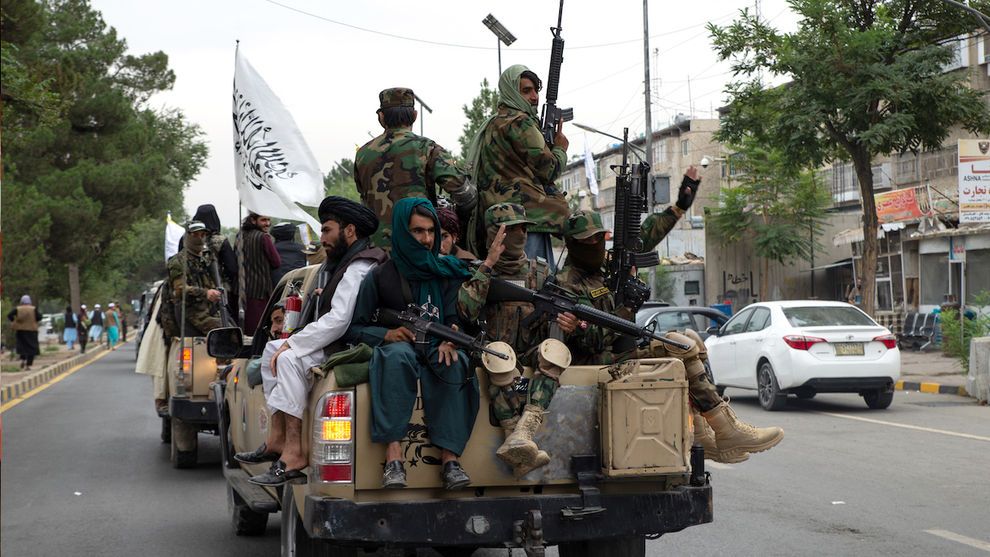 Taliban members ride in a pickup truck