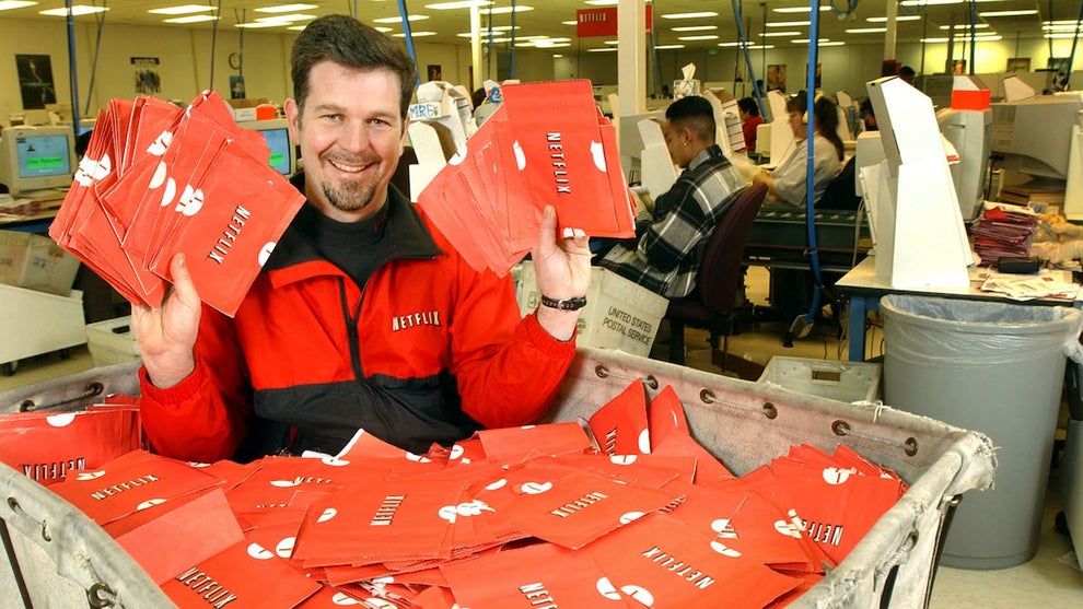 Netflix CEO Reed Hastings shows DVDs ready to mail at a San Jose, Calif., sorting center in 2002. The company announced Tuesday, April 18, 2023, that it would shutter its DVD rental business this year.
