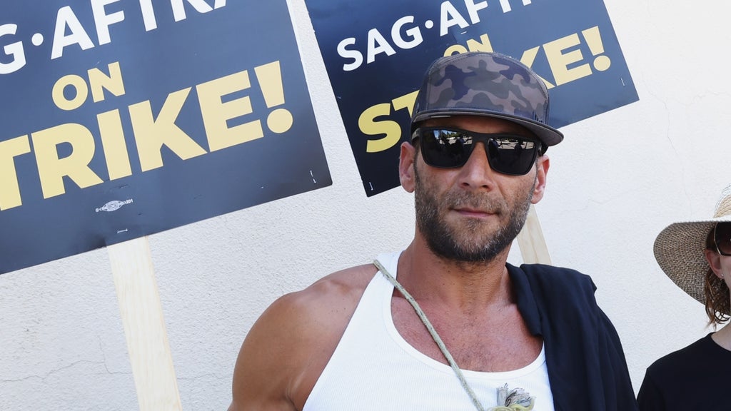 Zach McGowan (L) join members and supporters on the picket line at Warner Bros Studios on July 20, 2023 in Burbank, California.