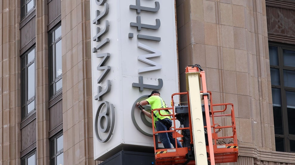 A worker removes letters from the Twitter sign that is posted on the exterior of Twitter headquarters (Photo Credit: Getty Collection)