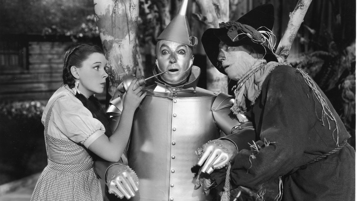 Dorothy and the Scarecrow oil up the Tin Man in "The Wizard of Oz." (Photo by MGM Studios/Courtesy of Getty Images)