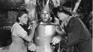 Dorothy and the Scarecrow oil up the Tin Man in "The Wizard of Oz." (Photo by MGM Studios/Courtesy of Getty Images)