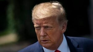 A close-up of former President Donald Trump, a man with light reddish skin and blonde hair