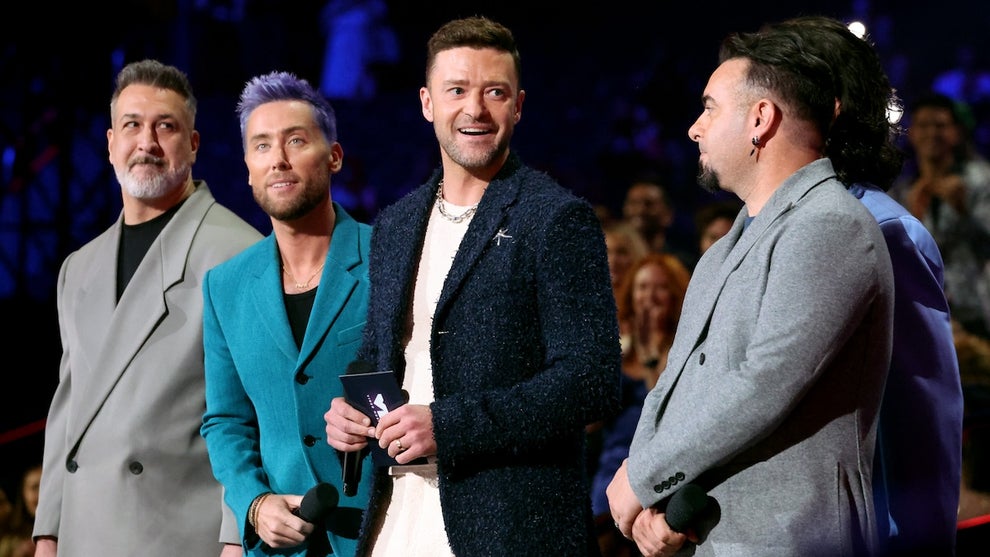 Members of the boy band NSYNC on stage wearing suits