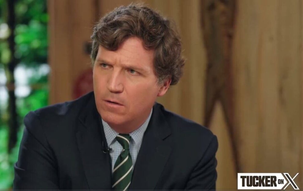 Host Tucker Carlson looks off the screen to his right.