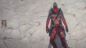 A man in a red costume lies on dusty ground.