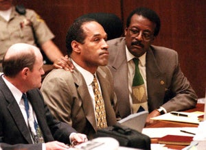 Lead defense attorney Johnnie Cochran (R) puts his arm on O.J. Simpson's (C) shoulder after Simpson told Judge Lance Ito 22 September 1995 in Los Angeles, CA, that he has faith that jurors will acquit him of the murder of his ex-wife Nicole Simpson and her friend, Ronald Goldman. At left is defense attorney Robert Blasier (L).