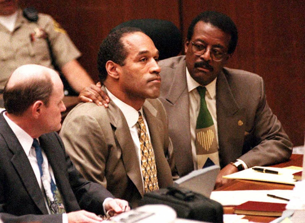 Lead defense attorney Johnnie Cochran (R) puts his arm on O.J. Simpson's (C) shoulder after Simpson told Judge Lance Ito 22 September 1995 in Los Angeles, CA, that he has faith that jurors will acquit him of the murder of his ex-wife Nicole Simpson and her friend, Ronald Goldman. At left is defense attorney Robert Blasier (L).