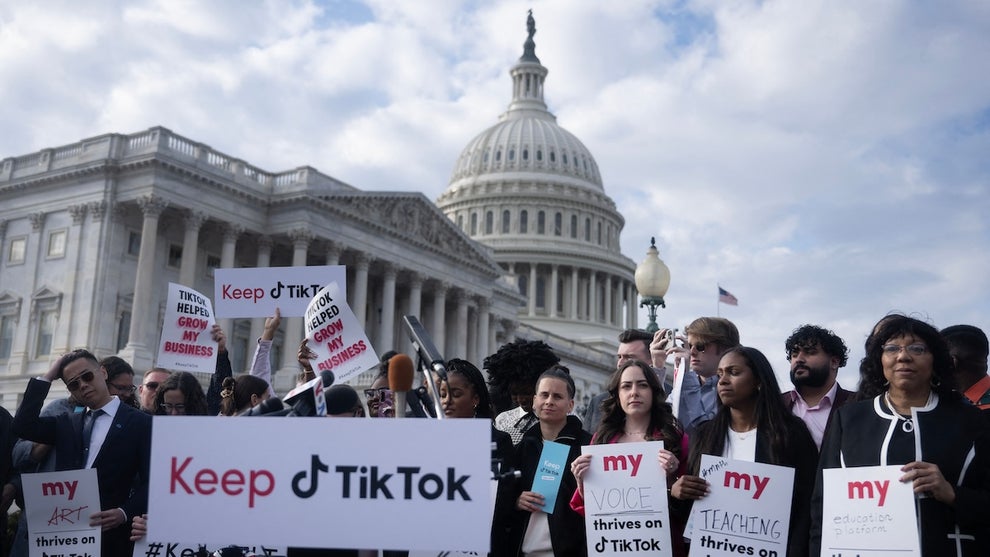 A group of people stand outside the U.S. Capitol building holding pro-TikTok signs, including a large banner reading "Keep TikTok." Other signs include fill-in-the-blanks with "my _____ thrives on TikTok," with items people have put in that space including art, voice, teaching, and education platform. Other signs read "TikTok helped grow my business."