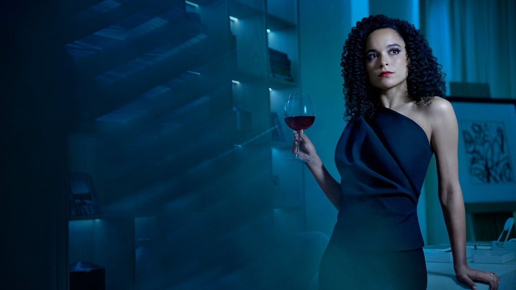 A woman wearing an elegant dress holds a glass of wine. Juliana Canfield in American Horror Story Delicate