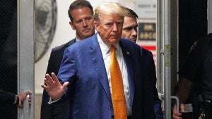 Donald Trump wearing a blue suit and yellow tie arriving in court