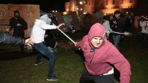 A Pro-Palestinian protestor clashes with a pro-Israeli supporter at an encampment at UCLA on April 30