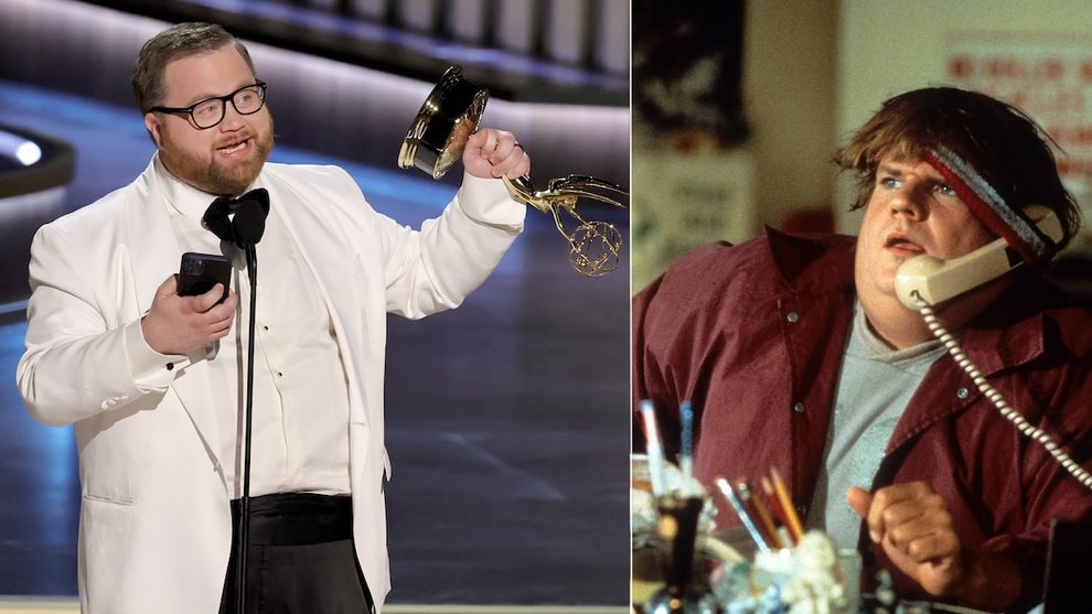 A man in a white tux wears glasses and holds his phone in one hand, an Emmy in the other on a stage on the left, standing in front of a microphone. A man on the right sits at a desk, on a phone, appearing dumbfounded.
