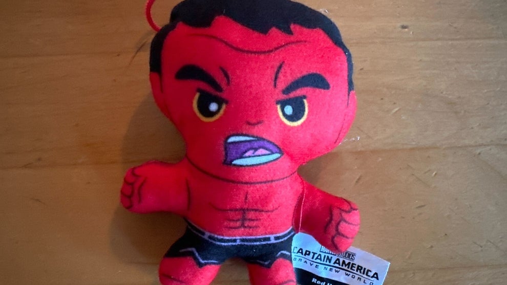 A Red Hulk toy, showing a red figure in dark shorts with black hair, appearing angry. The toy looks plush.