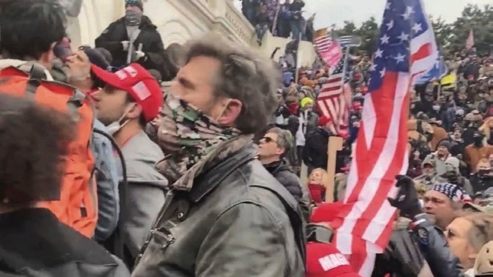 A crowd gathered outside the Capitol, including a man who appears to be Jay Johnston. The people are largely light-skinned.
