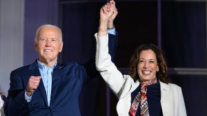 US President Joe Biden (L) and US Vice President Kamala Harris hold hands and gesture as they watch the Independence Day fireworks display from the Truman Balcony of the White House in Washington, DC, on July 4, 2024.