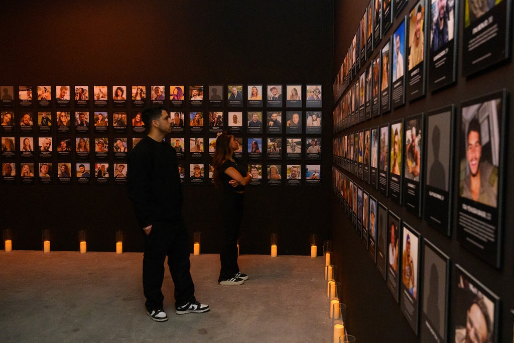 Nova survivor Natalie Sanandaji, and Reef Peretz, Chairman of the Nova Foundation, look at the names and faces of people killed during the Nova festival
