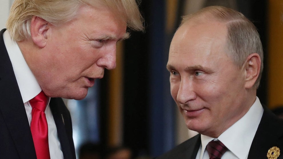 Two men with light-toned skin lean in and talk with one another.