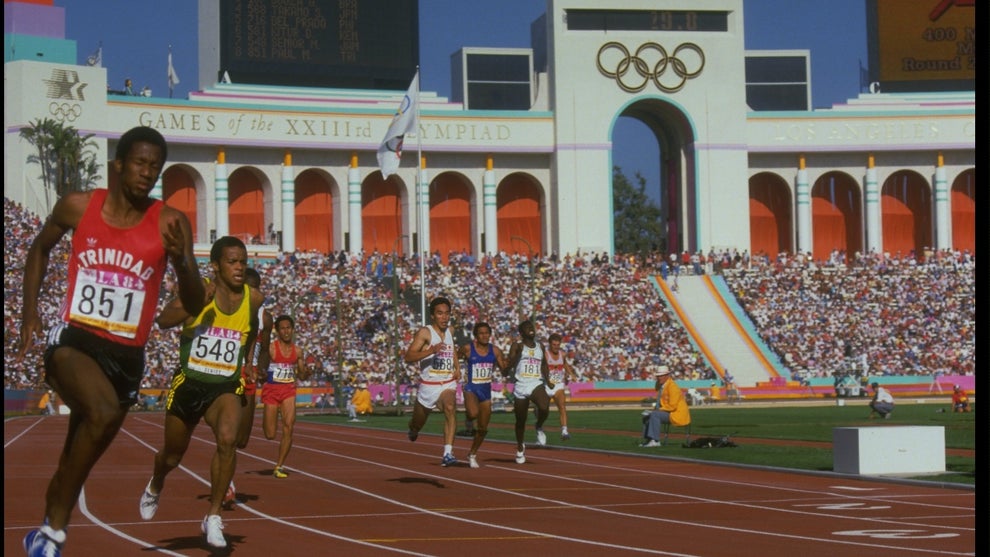 ATHLETES POWER THEIR WAY OFF THE BACK STRAIGHT DURING A HEAT FOR THE MENS 400 METRE AT THE 1984 LOS ANGELES OLYMPICS