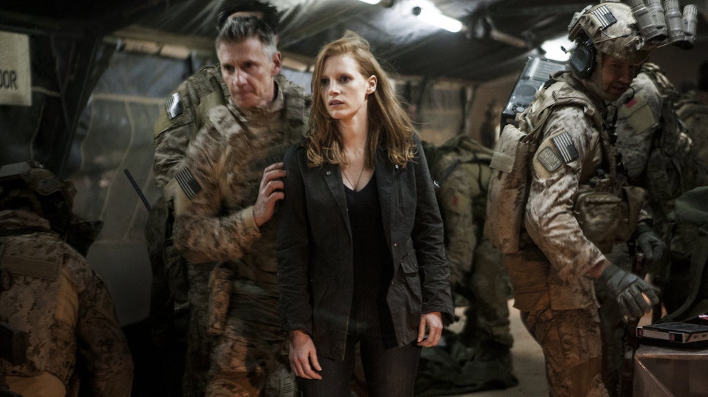 Stationed at a covert base overseas, Maya (Jessica Chastain) is a member of the elite team of spies and military operatives (Christopher Stanley, left, and Alex Corbet Burcher, right) who devote themselves to finding Osama bin Laden (Credit: Universal Pictures)