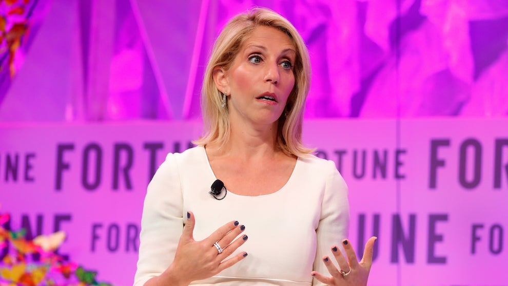 Dana Bash gestures with her hands on stage in front of a pink backdrop reading "Fortune."
