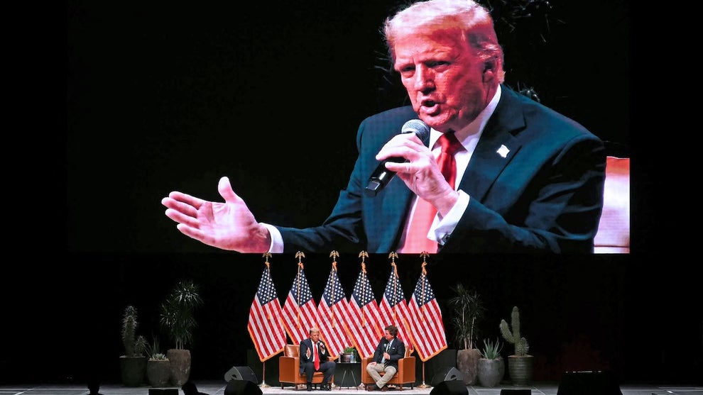 An image of Donald Trump on a video screen being shown to a crowd.