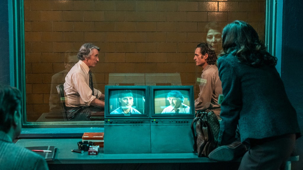 Steve Coogan as Paddy Meyers and Joaquin Phoenix as Arthur Fleck in "Joker: Folie à Deux" (Credit: Warner Bros. Pictures)