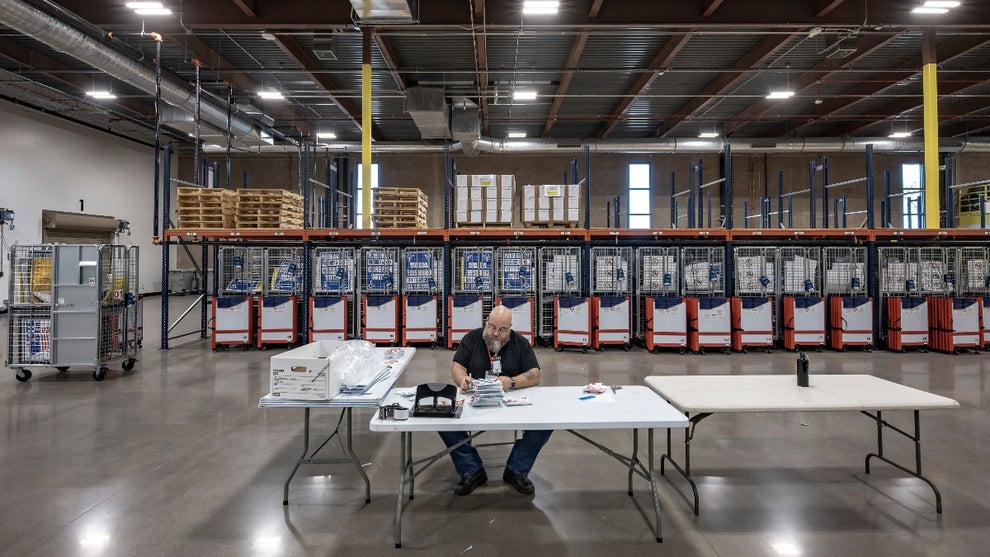 A poll worker prepares a poll station kit at the new electoral center for Pinal County in Florence, Arizona, on October 18, 2024