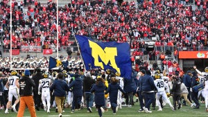 Michigan Wolverines players fly a flag prior to a brawl between players (Credit: Ben Jackson/Getty Images)