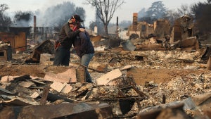 Khaled Fouad and Mimi Laine embrace as they inspect a family member's property that was destroyed by Eaton Fire (Credit: Justin Sullivan/Getty Images)