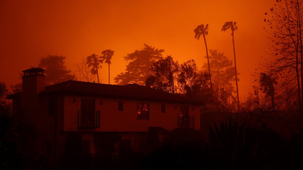 The sky glows orange as the Eaton Fire moves through the area on Jan. 8. (Credit: Justin Sullivan/Getty Images)