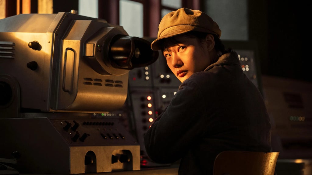 Zine Tseng sits in front of a radio transmitter's controls in "3 Body Problem."