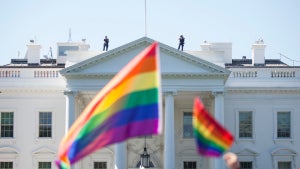 Demonstrators carry rainbow flags past the White House (Credit: Zach Gibson/Getty Images)