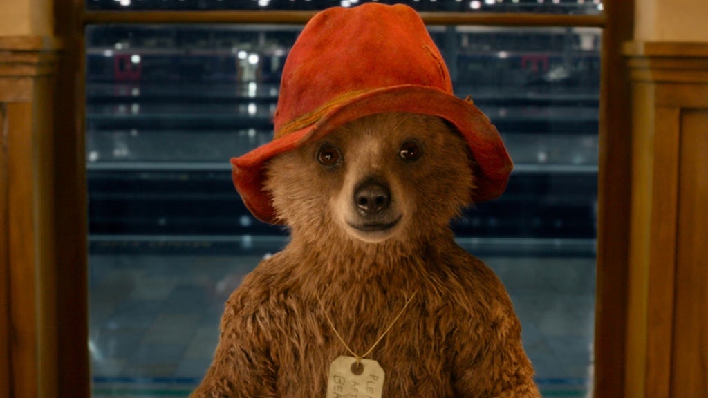Paddington Bear stands in a doorway in "Paddington."