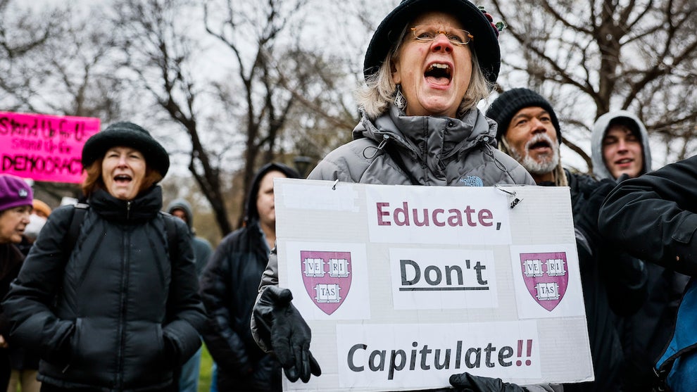 A protester holds a sign reading "Educate, Don't Capitulate!!" during a rally at Cambridge Common (Credit: Erin Clark/The Boston Globe via Getty Images)