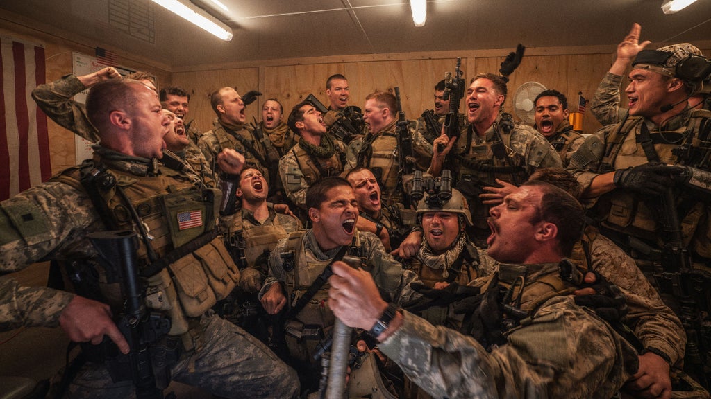 The cast of "Warfare" sings and dances in the film's opening scene. (A24)