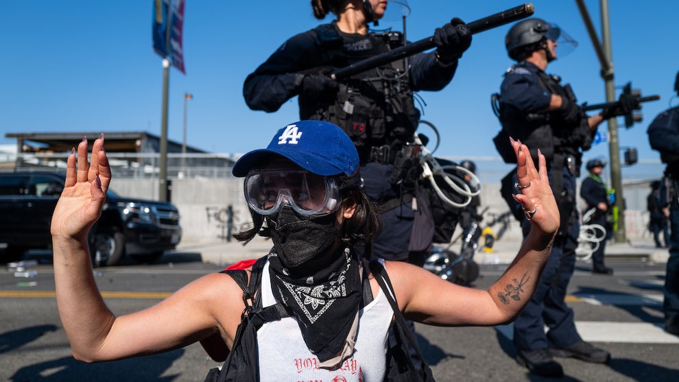 A protester raises their hands in front of LAPD officers during protests in Los Angeles on June 8, 2025. (Credit: Spencer Platt/Getty Images)
