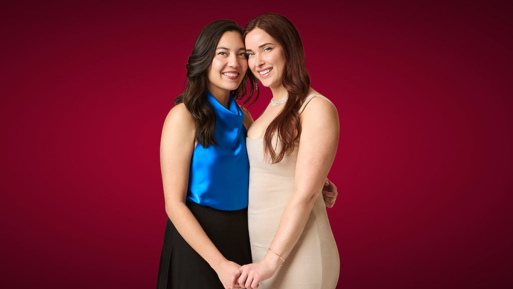 Two women smile and pose in front of a red background. Haley and Pilar in Season 2 of "The Ultimatum: Queer Love" (Credit: Melody Timothee / Netflix)