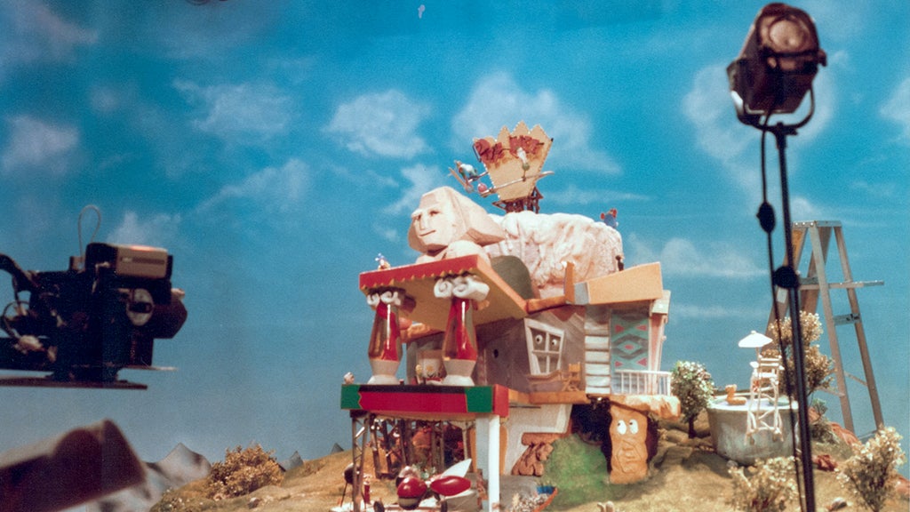 Pee-wee's playhouse stands in front of a camera under lights