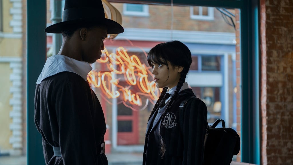 A young man dressed as a pilgrim shares a tense stare-down with Wednesday Addams 