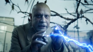Fred Armisen's Fester Addams shoots electricity out of his fingers in an aviary